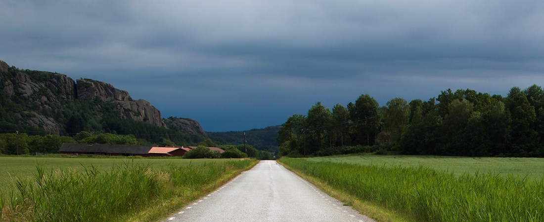 Mörka moln över en landsväg. 