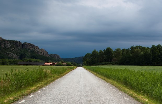 Mörka moln över en landsväg. 